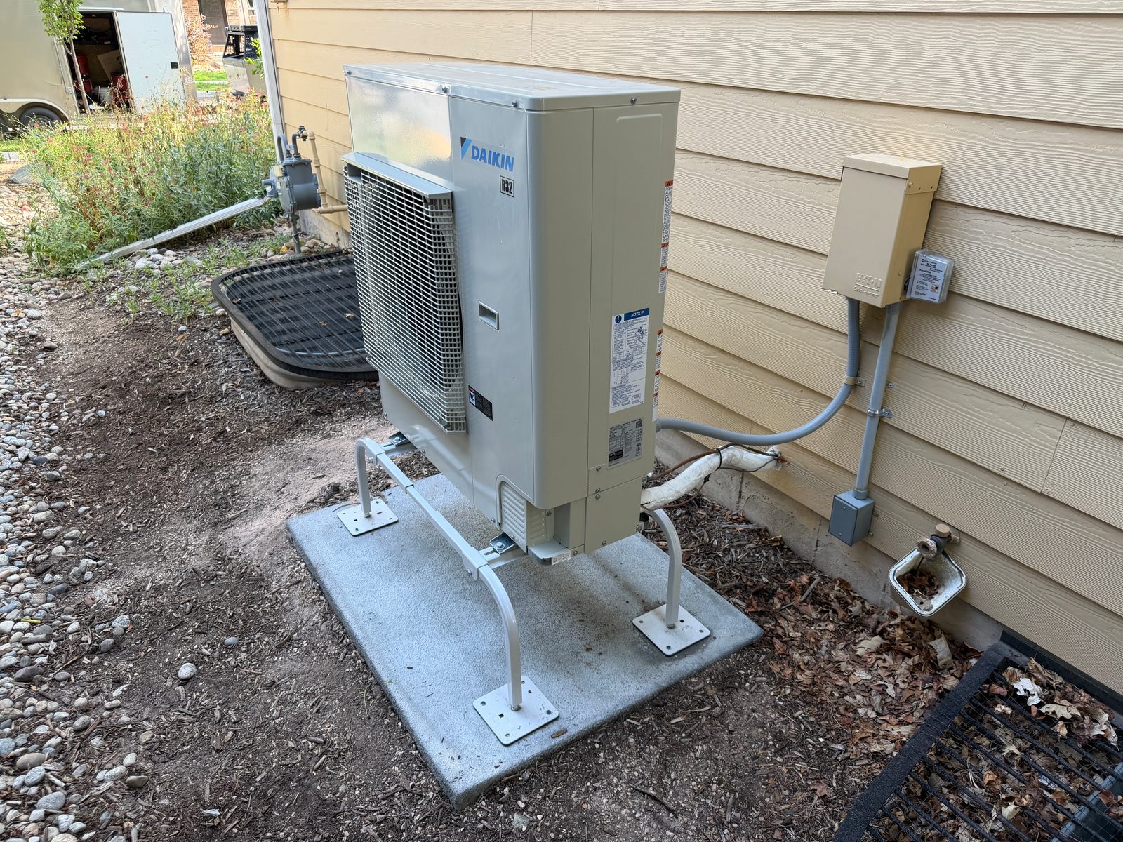 Daikin cold-climate heat pump on a pad and stand