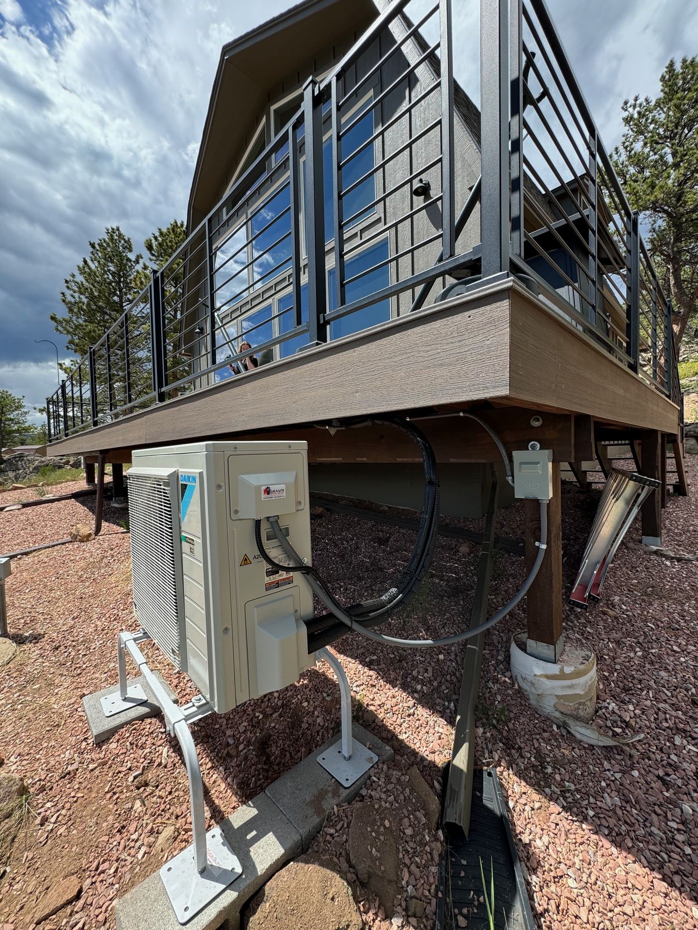 Daikin mini-split outdoor unit under a mountain deck